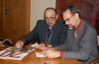 Pan Sova s ředitelem školy nad pamětnickými fotografiemi maturitní třídy.